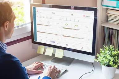 A man in an office using Alpega Analytics software to analyse his company’s transportation 
